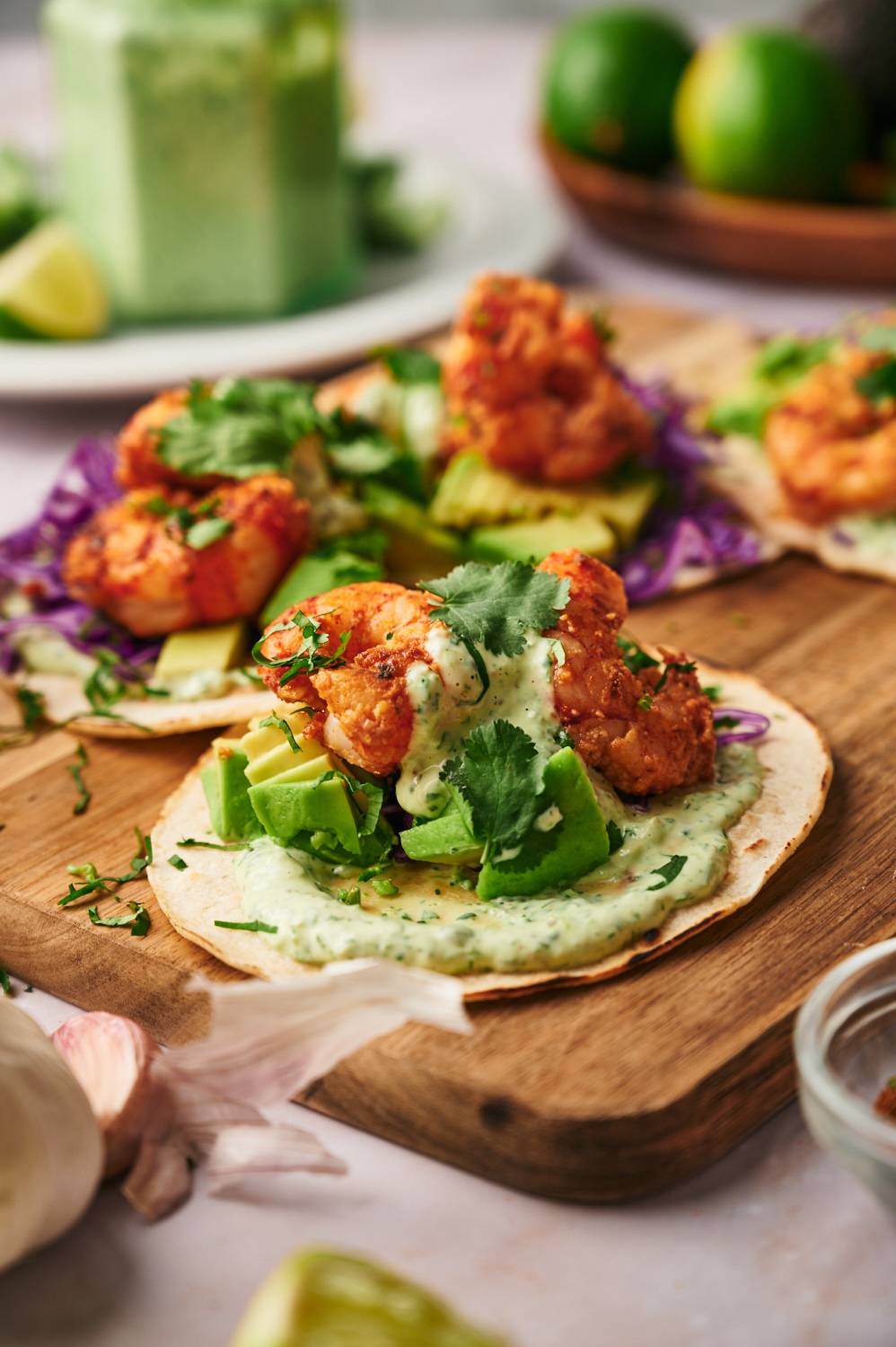 Mexican shrimp tacos with crispy shrimp, cialntro sauce, cabbage, avocado, and lime juice on corn tortillas.