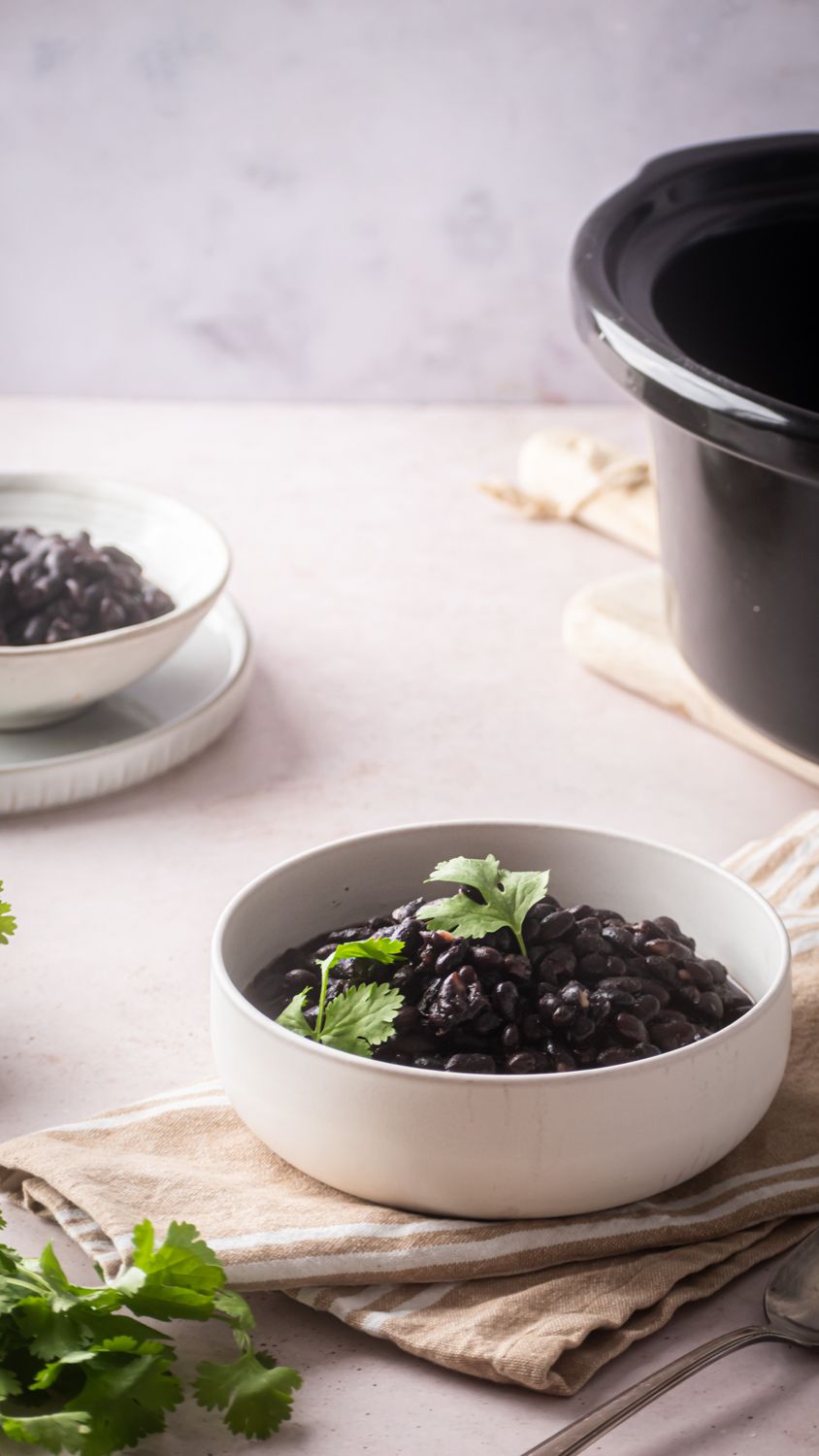 Black beans cooked in the slow cooker and served in a bowl with cilantro.