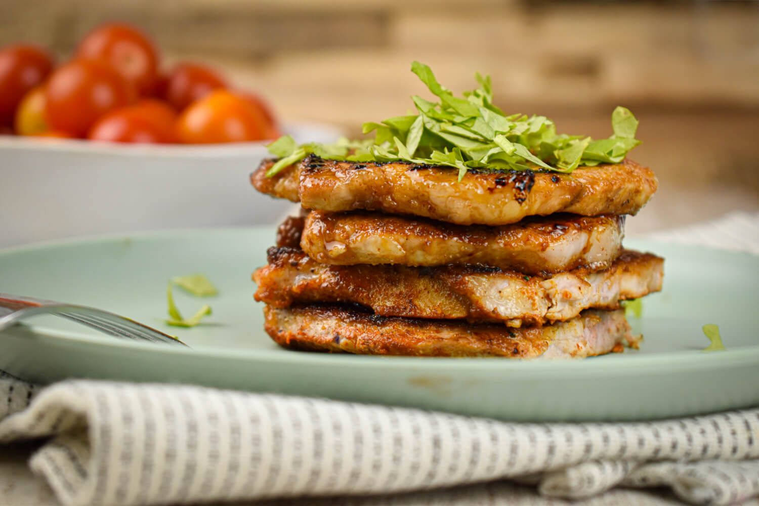 Sweet and spicy pork chops piled on a brown sugar spice rub on a plate with parsley.