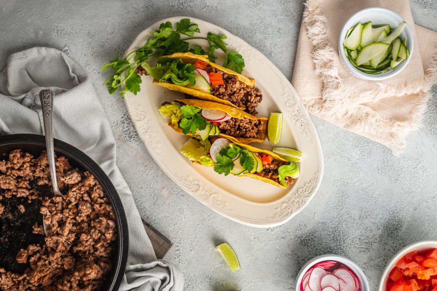 Ground beef tacos with ancho chili seasoning served in baked taco shells with lettuce, tomato, and cilantro.