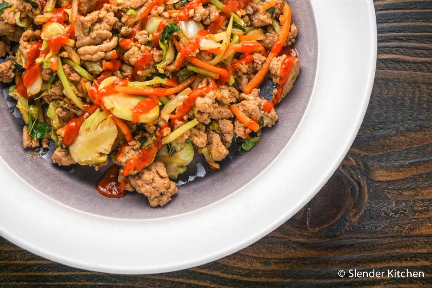 Whole30 Asian turkey stir fry with shredded cabbage, carrots, broccoli, and Brussels sprouts in a garlic, ginger, and soy based sauce. 