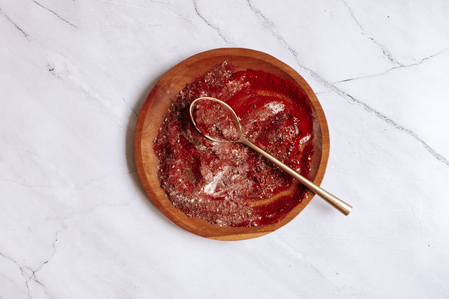 Blackening seasoning on a wooden plate with paprika, garlic powder, oregano, and more.