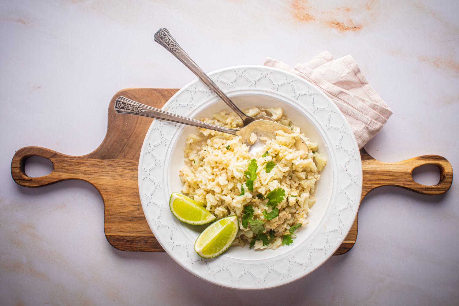 Coconut cauliflower rice with riced cauliflower cooked with ginger, garlic, and coconut milk in a white bowl.