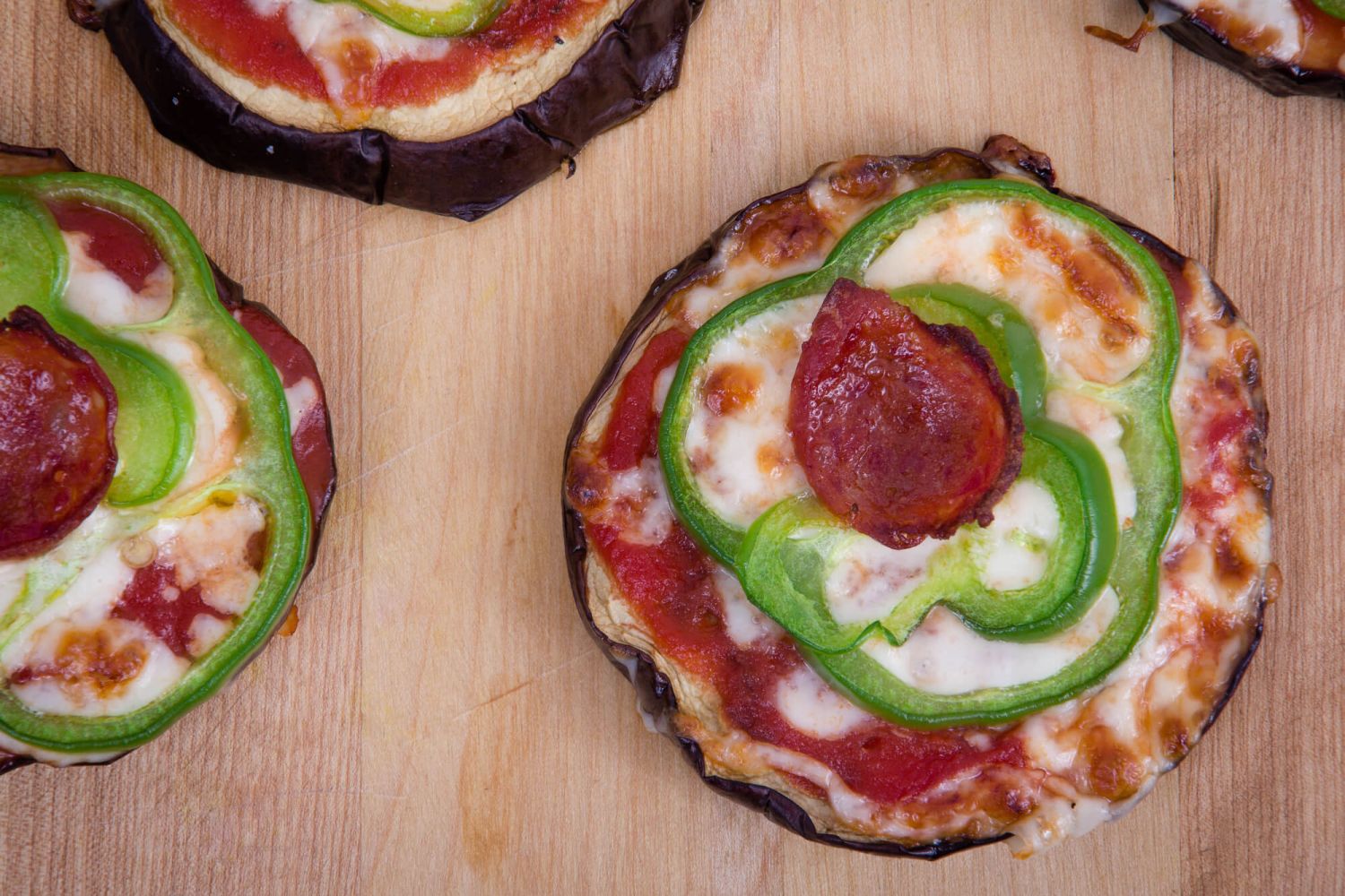 Eggplant pizza bites with roasted eggplant, tomato sauce, mozzarella cheese, bell peppers, and pepperoni.