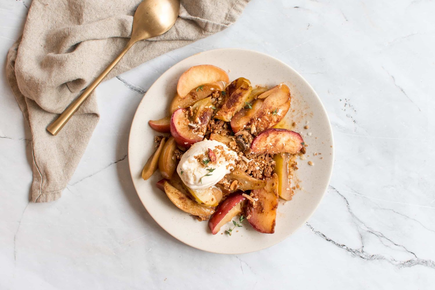 Grilled apples in a foil packet with cinnamon, yogurt, and granola on a plate.