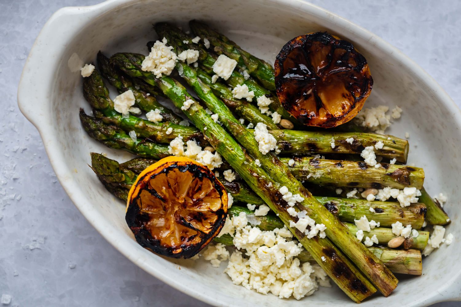 Grilled lemon asparagus topped with crumbled feta cheese and served with grilled lemon halves.