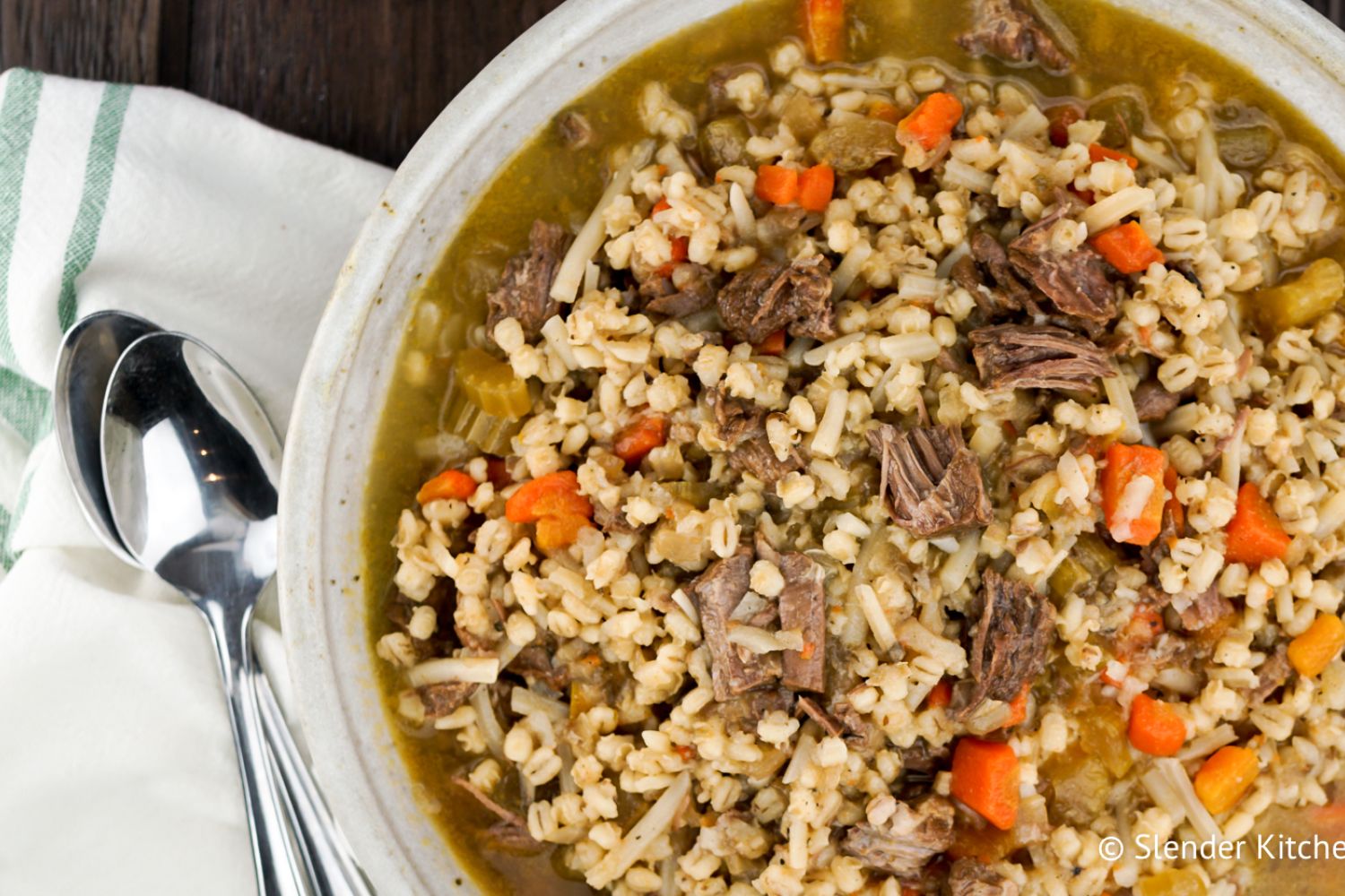 Instant Pot Beef and Barley Soup with carrots, celery, potatoes, and beef in a bowl.