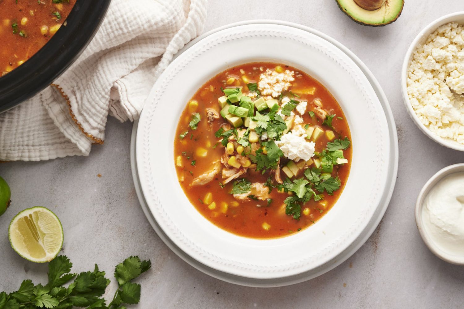 Mexican chicken soup with shredded chicken, corn, onions, avocado, cilantro, and queso fresco.