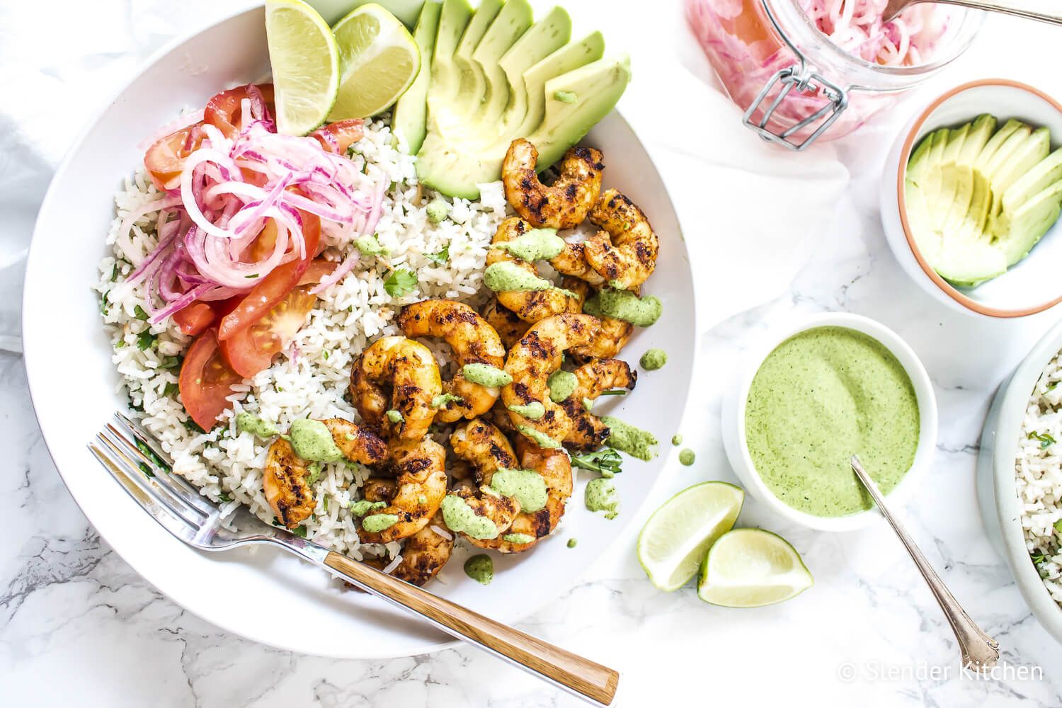 Shrimp rice bowls with grilled shrimp, white rice, cilantro mint sauce, salsa criolla, and sliced avocado.