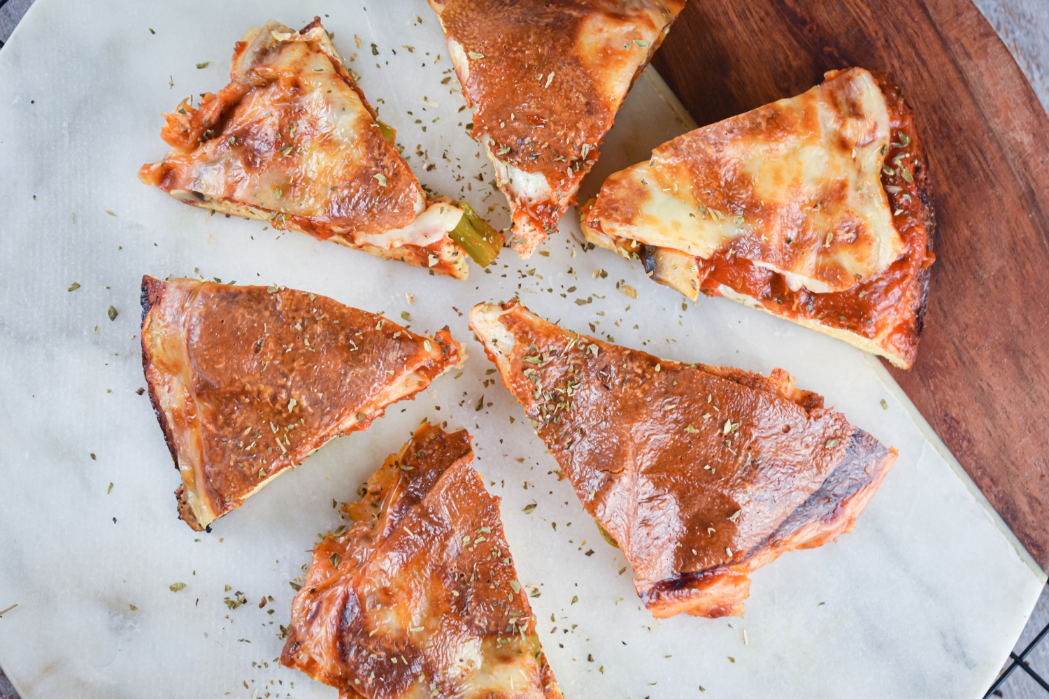 Pizza frittata with tomato sauce and melted cheese cut into slices on a cutting board.