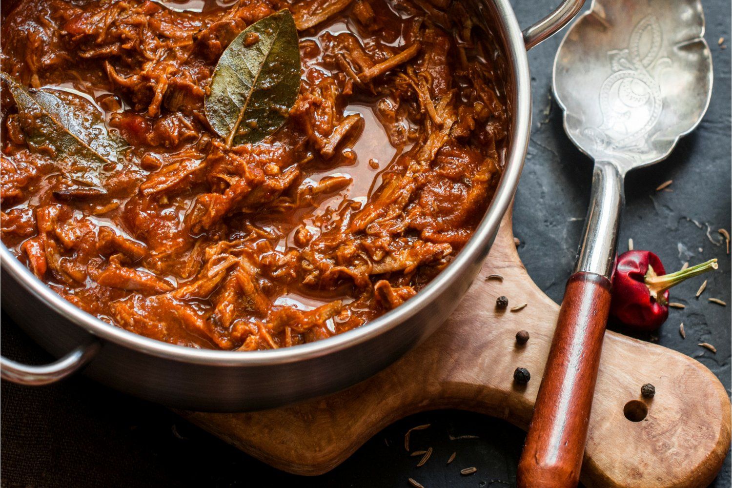 Slow cooker beef rago with shredded beef, tomato sauce, and fresh basil.