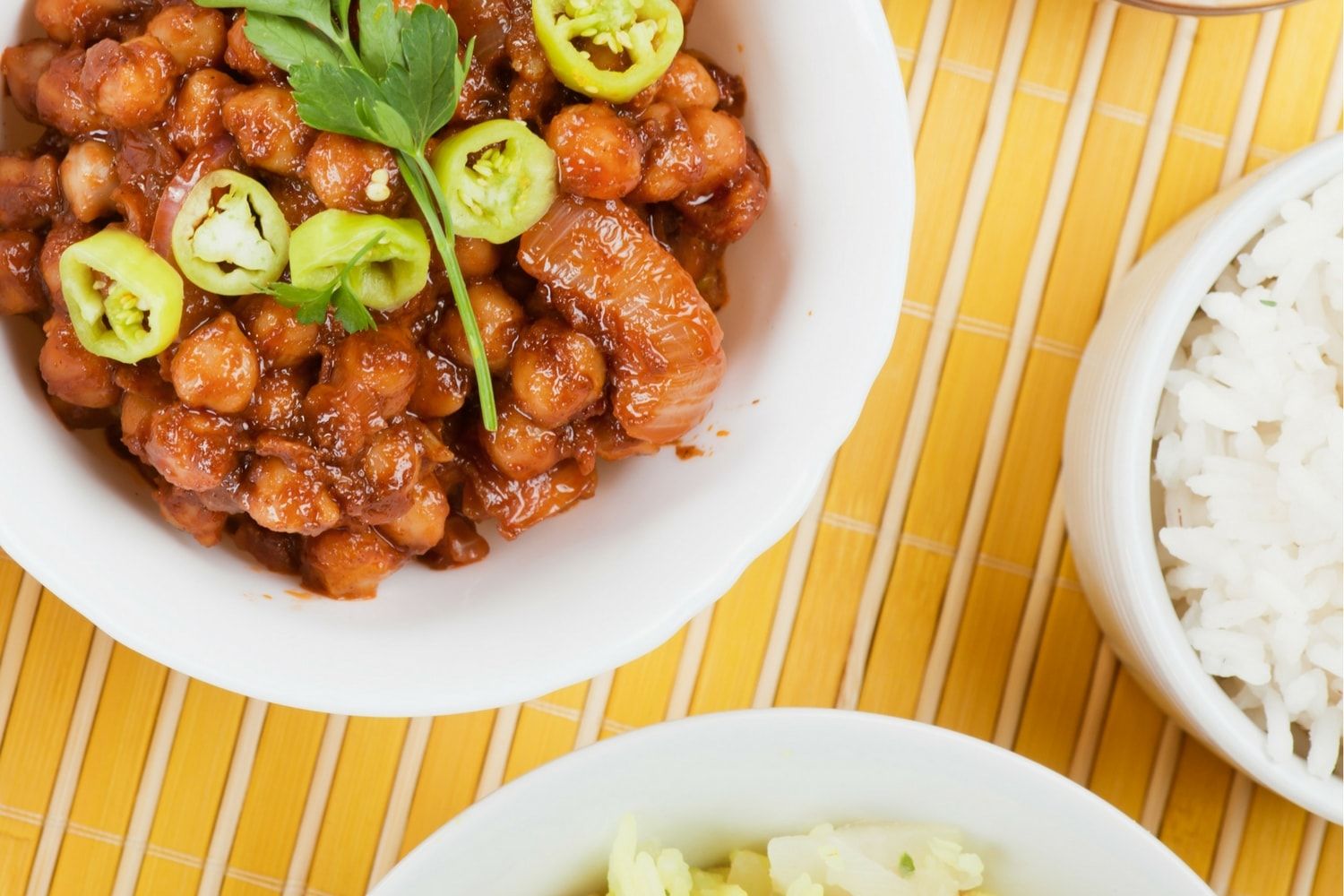 Slow cooker sweet and spicy chickpeas in a bowl with sliced jalapenos on top.