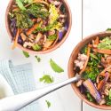 Asian ground turkey stir fry with kale, carrots, broccoli, and soy sauce in two bowls.