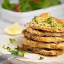 Parmesan crusted pork chops piled high with parsley and lemon slices.