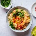 Baba ganoush eggplant dip with tahini, olive oil, and garlic topped with parsley in a bowl.