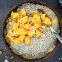 Chia seed pudding with mango on top in a wooden bowl.