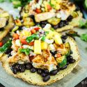 Salmon tostadas with blackened salmon, zucchini, veggies, and cheese on a crispy tortilla.