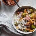 Brussels sprout pasta with bacon and Parmesan cheese in a bowl with a spoon.