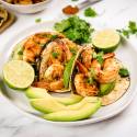 Cajun shrimp tacos in corn tortillas with sliced avocado, cilantro, and fresh lime juice.