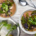 Chicken coconut curry soup with fresh vegetables, chicken breast, and red curry paste in a bowl.