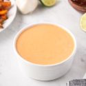 Creamy chipotle sauce with Greek yogurt, mayonnaise, and chipotle peppers in a small white bowl with fries on the side.