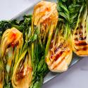 Grilled bok choy with sweet chili sauce served on a plate. 