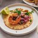 Grilled shrimp tacos with pineapple slaw served on toasted corn tortillas with lime and cilantro.