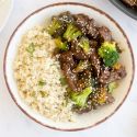 Healthy beef and broccoli served on a plate with steamed rice.