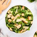 Healthy caesar salad with greens, croutons, parmesan cheese, and a lightened  up dressing.