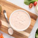 Healthy Thousand Island dressing in a bowl with ketchip, yogurt, relish, and salad on the side.