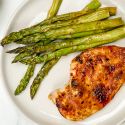 Honey garlic chicken on a plate with asparagus.