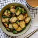 Honey mustard Brussels sprouts in a bowl with the sauce in a small bowl on the side.