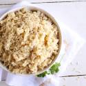 Instant pot brown rice in a bowl with small flecks of dried parsley.