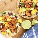 Shrimp Mango Tostadas with black beans, cabbage, corn, mango, cilantro, and avocado.