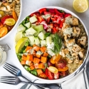 Mediterranean Bowls with chicken, cucumbers, red peppers, feta cheese, sweet potatoes, and tahini dressing.