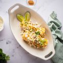 Mexican street corn on the cob with mayo, queso fresco, lime, cilantro, and chili powder.