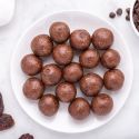 Date Brownie Bites with chocolate chips, Medjool dates, cashews, and almonds on a plate.