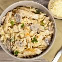 Chicken and Mushroom Pasta in a creamy sauce in a pan with a napkin on the side.