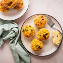 Quinoa egg muffins with cooked quinoa, eggs, broccoli, sundried tomatoes, and shredded cheese served on a plate.