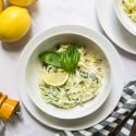 Creamy ricotta zucchini noodles with creamy cheese sauce, lemon, and basil leaves.