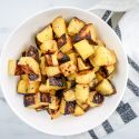 Roasted turnips with olive oil in a white bowl with a blue napkin.