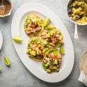 Salmon tostadas with creamy avocado, spice coated salmon, and pineapple salsa on crispy corn tortillas.