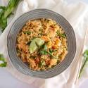 Shrimp fried rice with asparagus, cilantro, and a lime wedge in a bowl.