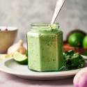 Creamy shrimp taco sauce with cilantro, yogurt, garlic, lime, mayonnaise, and jalapeno in a jar with a spoon.