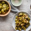 Slow cooker Brussels sprouts in a bowl with Parmesan cheese, lemon, and balsamic glaze.