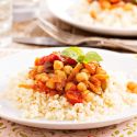 Mediterranean chickpeas in a bowl with tomatoes, fresh herbs, and garlic. 