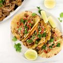 Slow Cooker Korean Pork served in corn tortillas with slaw and hot sauce.