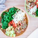 Mexican lentil soup with lentils in a spicy tomato broth served with brown rice, spinach, and zucchini in two bowls.