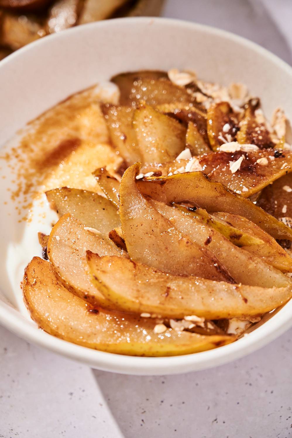 Bowl of grilled pears with yogurt, cinnamon, and walnuts. 