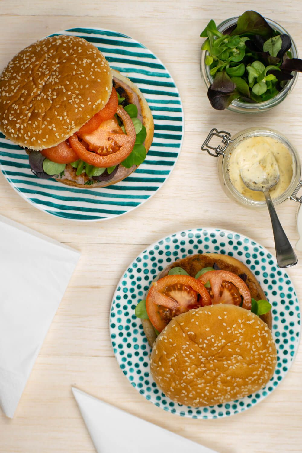 Chicken burgers with caesar dressing on buns with tomato and lettuce.